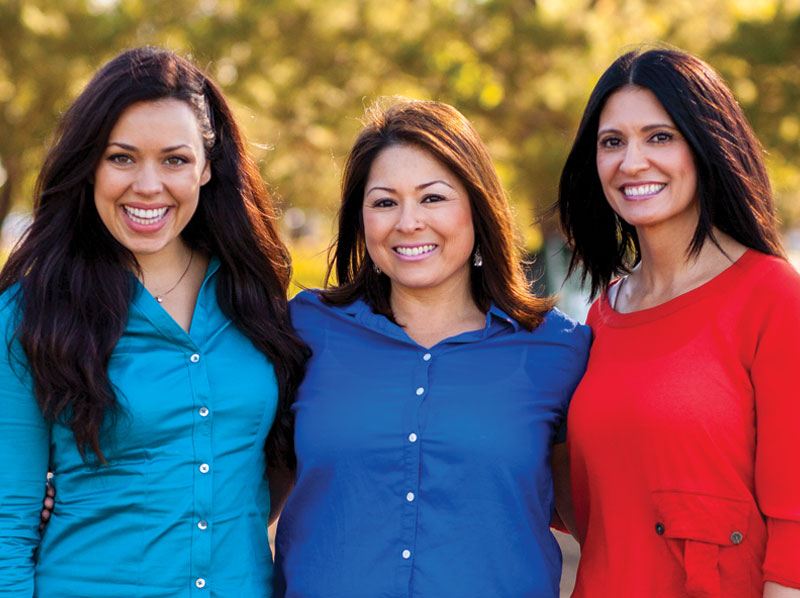 Three women friends smiling outdoor.